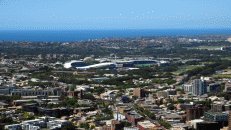 Richtung Südost erblickt man zwei wichtige Stadien der Stadt: Ganz in Weiß das Allianz Stadion mit dem ersten ausschließlich rechteckigen Spielfeld in Australien für Rugby und Fußball. Rechts daneben der Sydney Cricket Ground.
